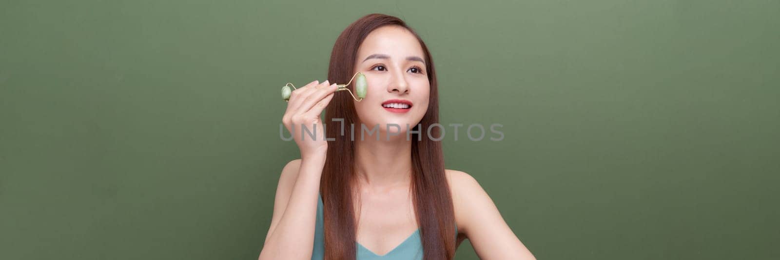 Panorama of girl uses beauty gua sha jade quartz roller. 