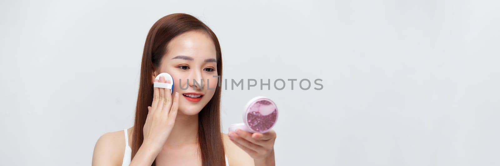 Glamorous beautiful female applying cushion powder for facial makeup concept on banner