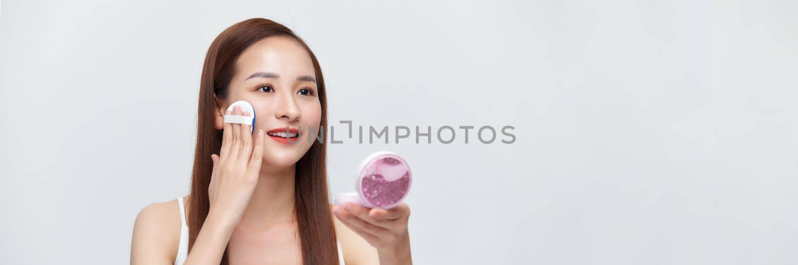 Banner of flawless perfect cosmetic skin woman put powder puff on her face in isolated background.