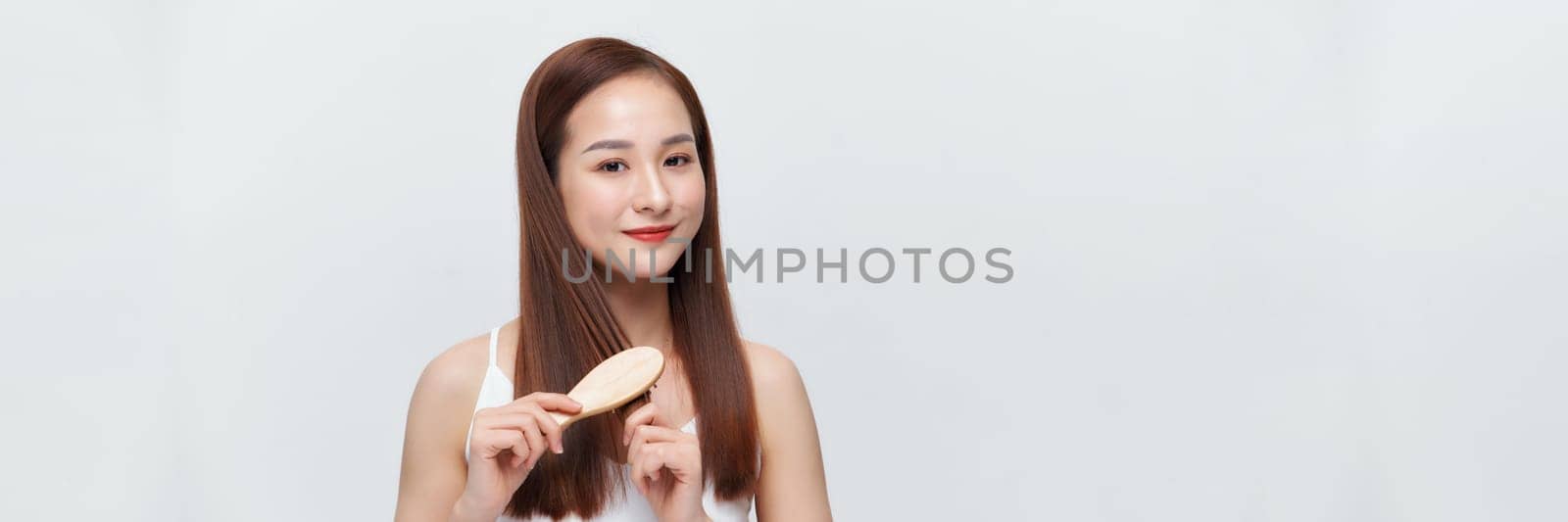 Banner of young woman brushing her hair and smiling isolated over white background