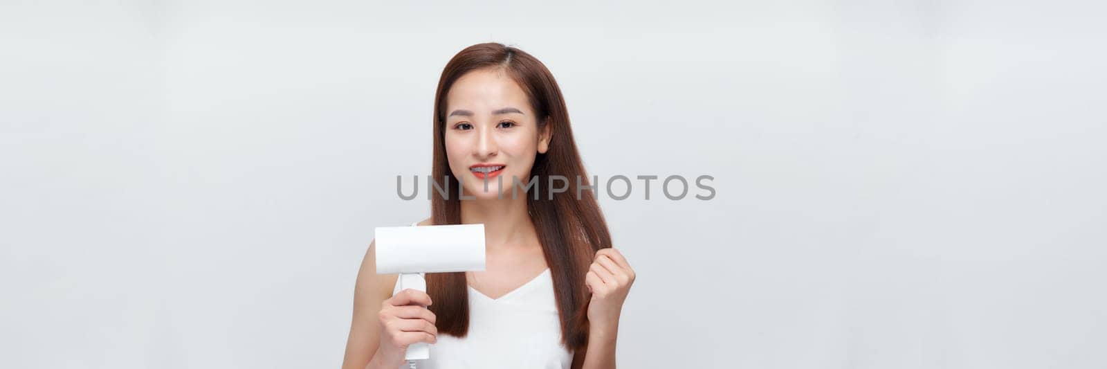 Beautiful young woman using hair dryer on white background. Panorama