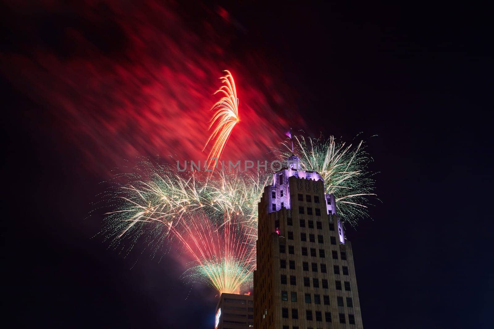 Red and white fireworks lighting up night sky behind Lincoln Tower on 4th of July by njproductions
