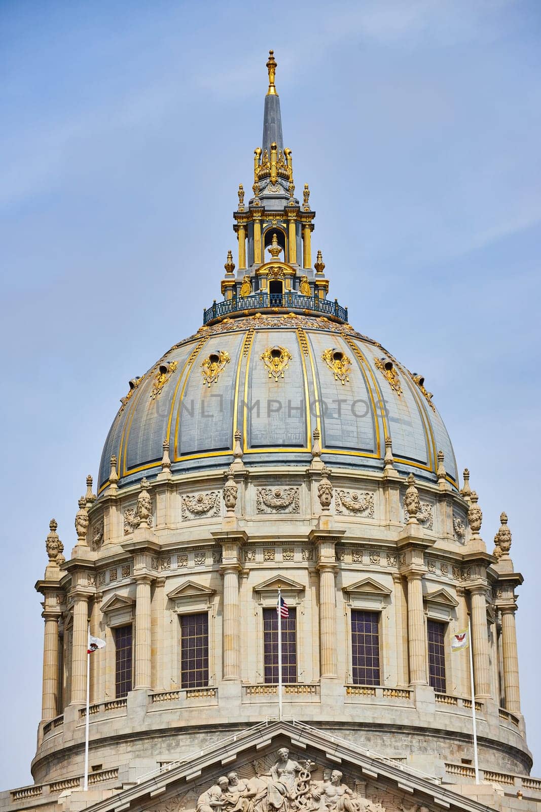 Image of Close up of city hall entrance with focus on gilded dome with flags in San Francisco