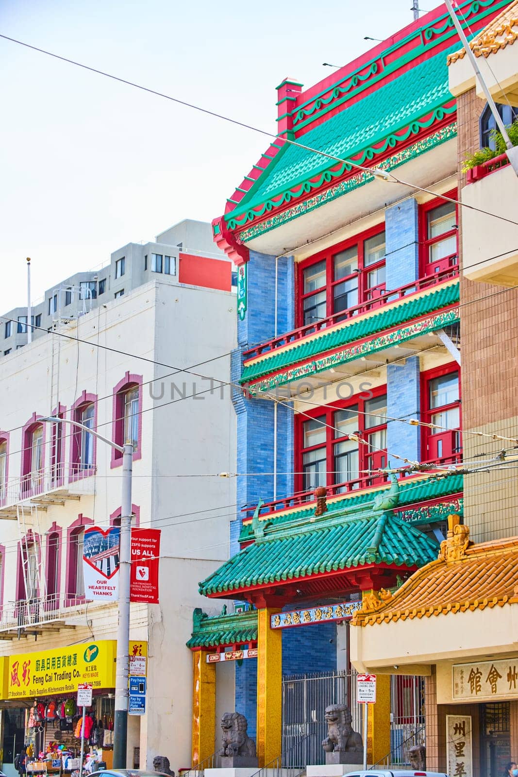 Image of Traditional Chinese building in Chinatown with green roof and red shutters and lion statues