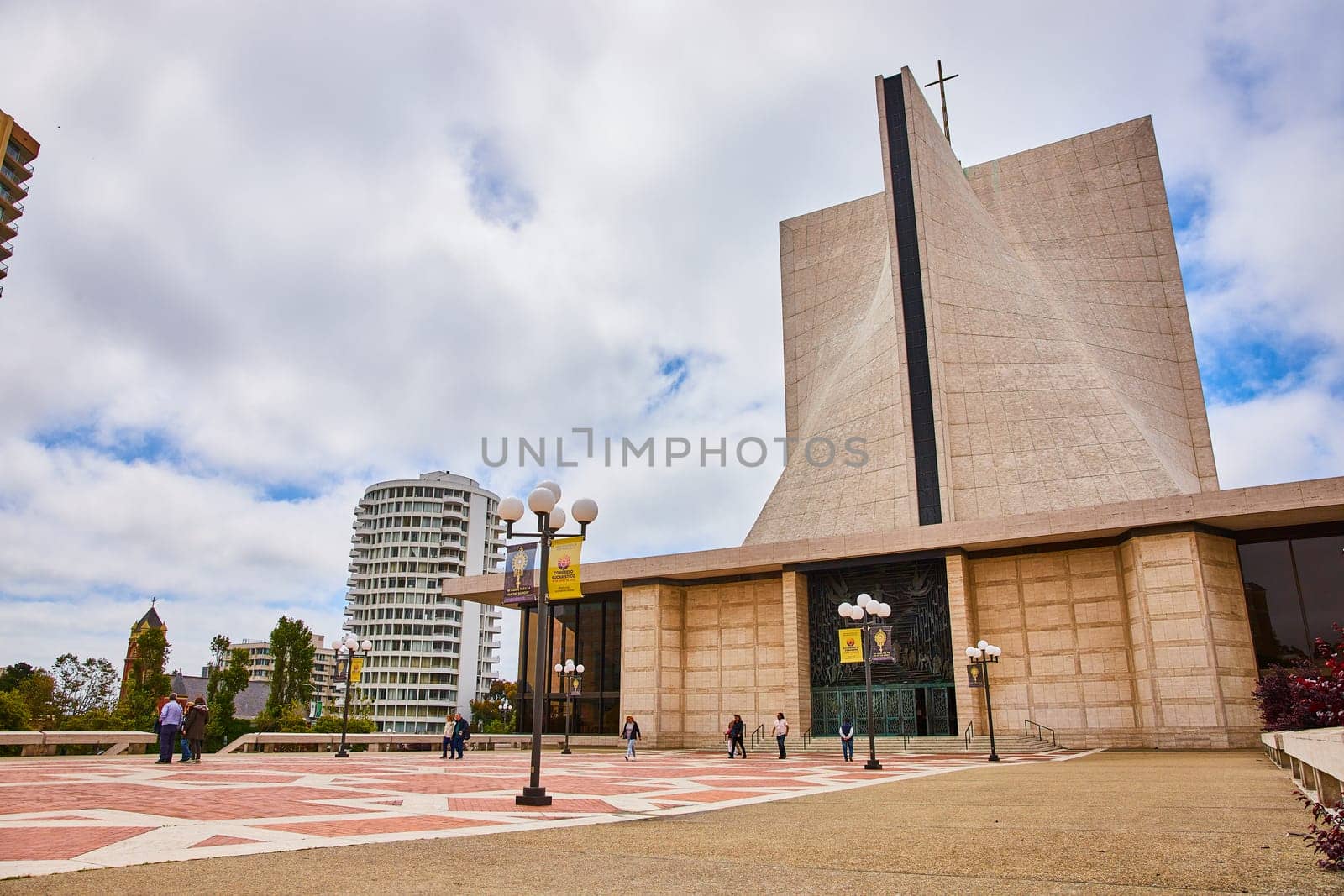 Image of People walking on sidewalk entrance of Cathedral of Saint Mary of the Assumption on cloudy day