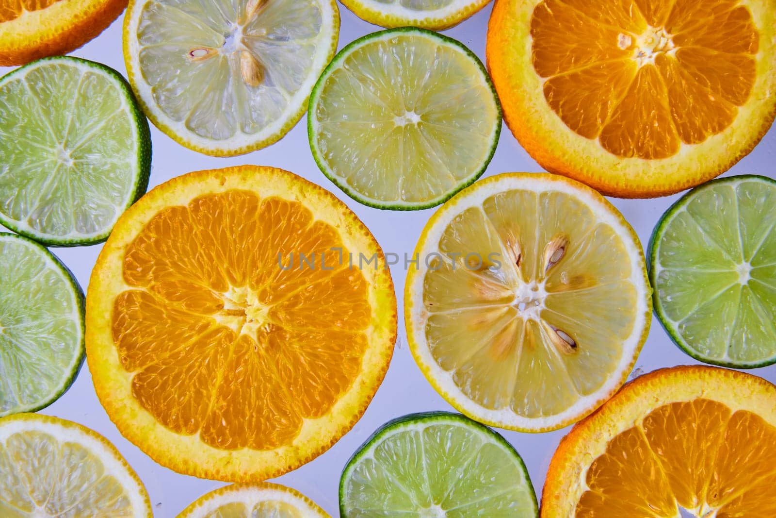 Wall of citrus fruits on white background with lemons and limes and oranges by njproductions