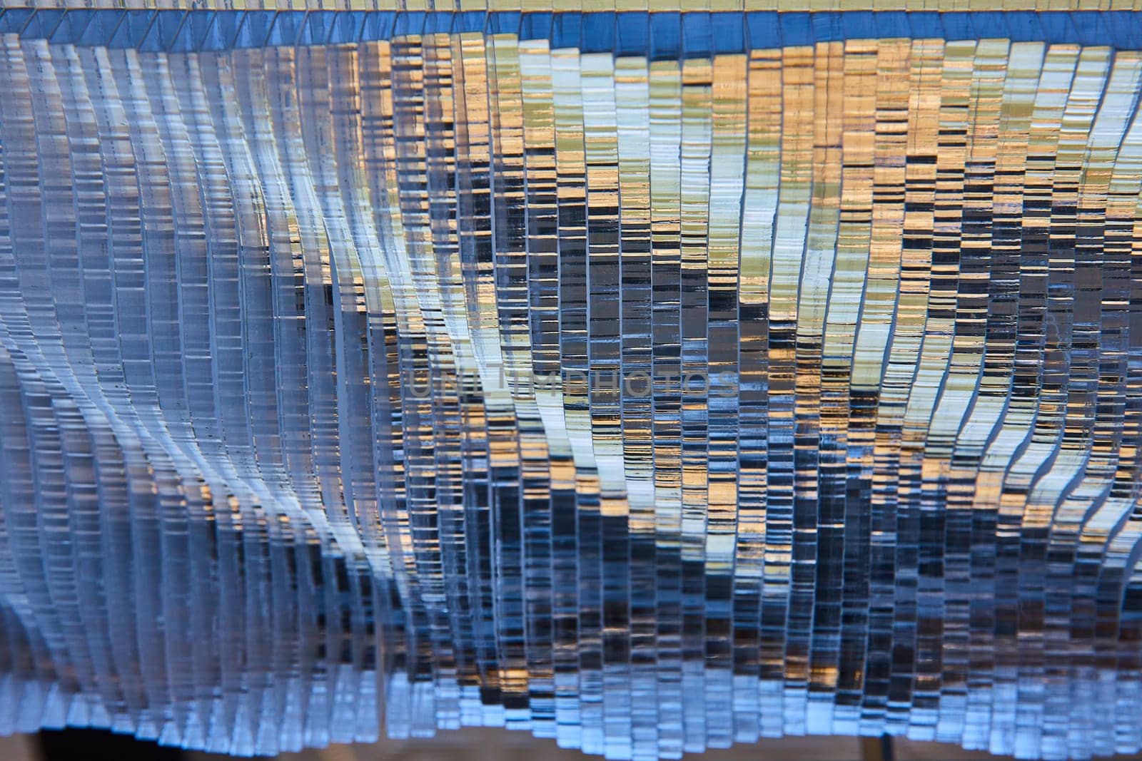 Image of Silvery metallic waves with golden highlights and blue shadows