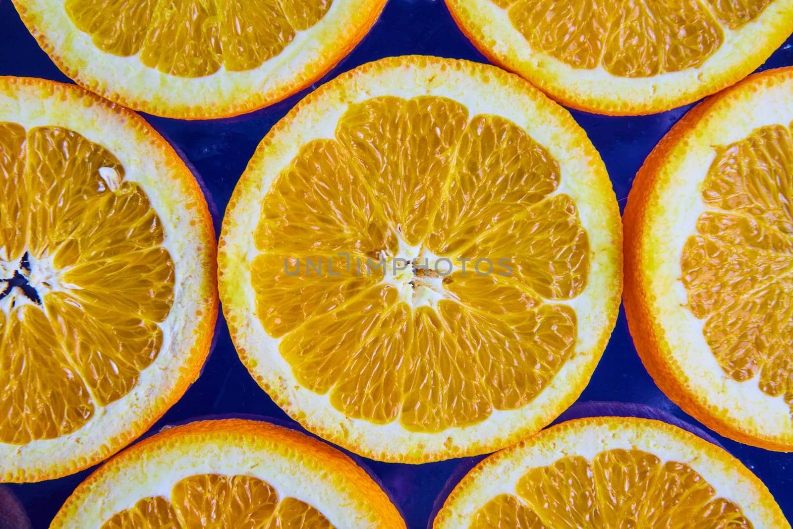 Image of Macro of orange slices with seeds on navy blue background