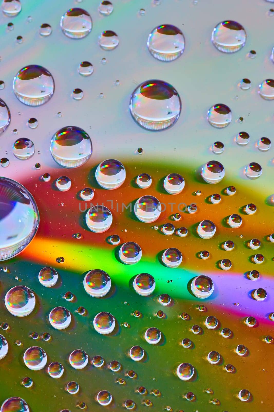 Image of Laser burst of rainbow light across reflective metallic surface with bubbles abstract asset