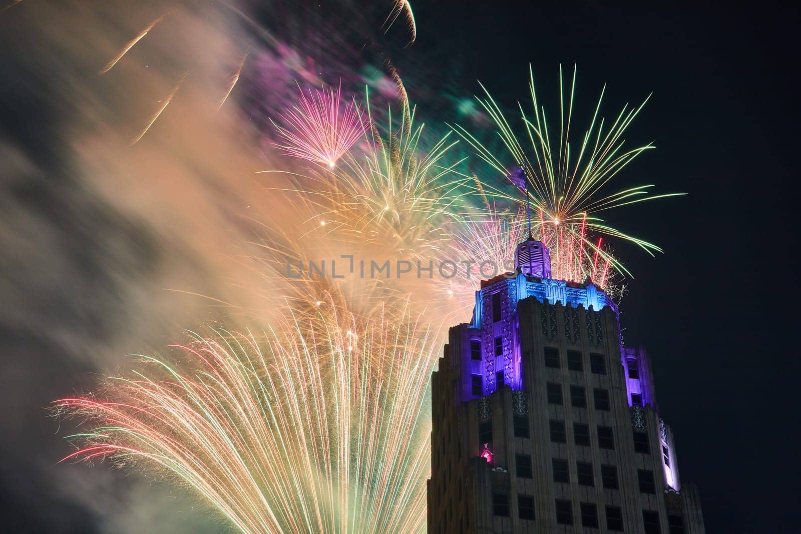 Zoomed in view of dazzling fireworks behind Lincoln Tower with purple and blue lights in Fort Wayne by njproductions