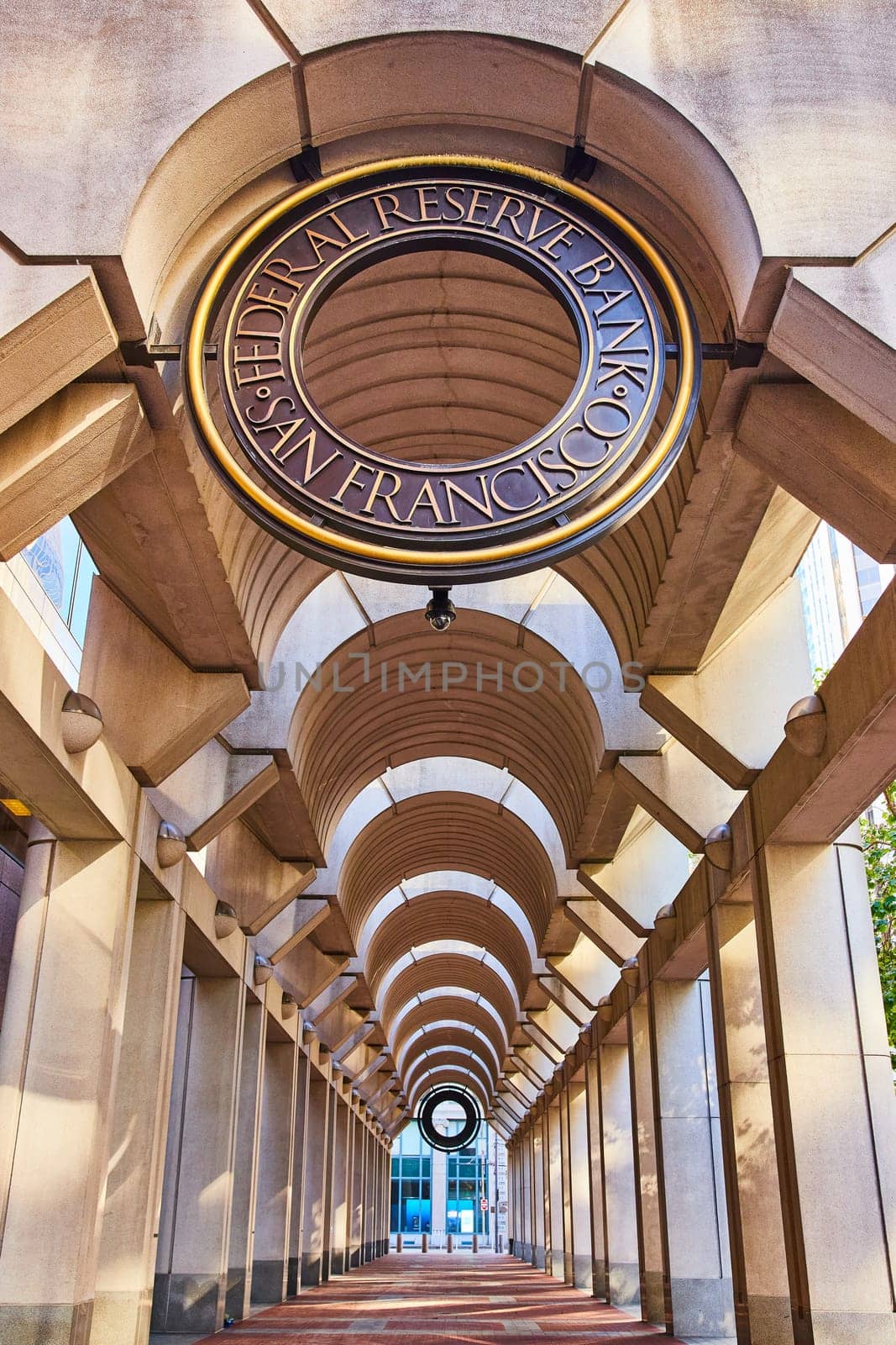 Image of San Francisco Federal Reserve Bank walkway with curved ceiling and red brick ground