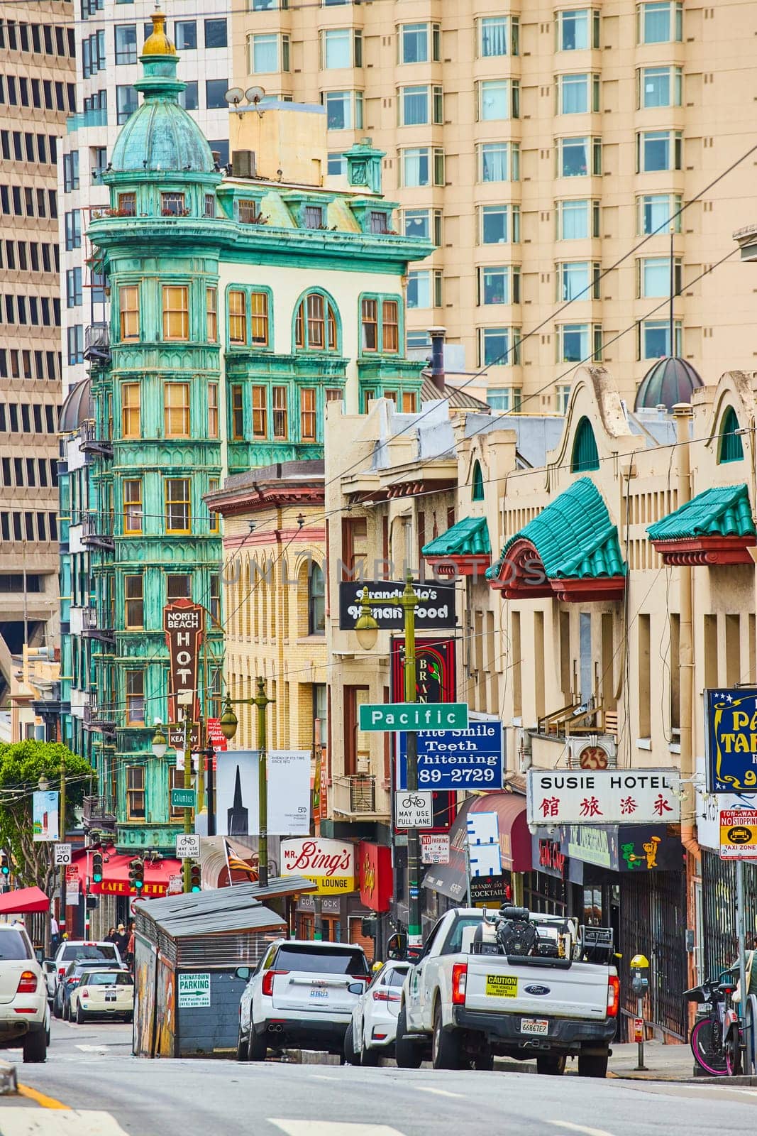 Image of Street view of Chinatown shops and restaurants with apartment buildings looming in distance
