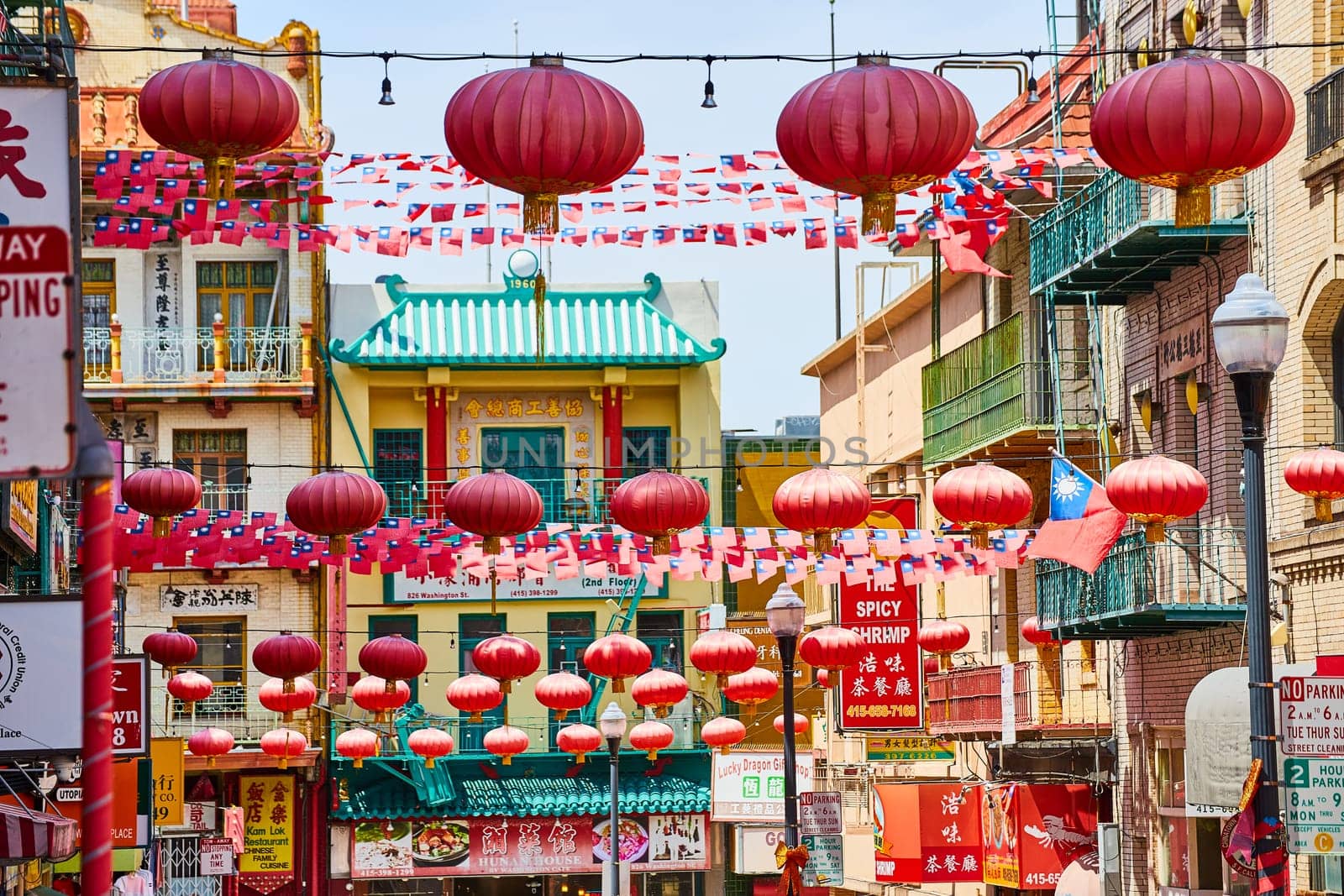 Image of Red paper lanterns with Chinese and American flags strung across road in Chinatown