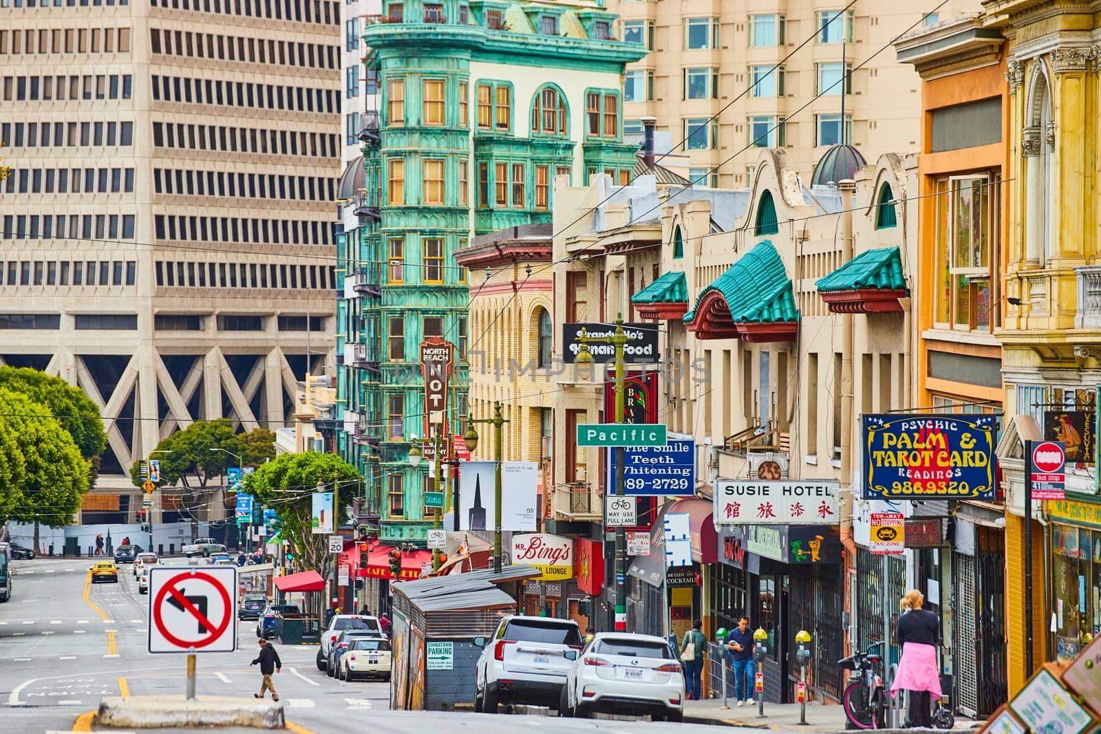 Image of Street view of Chinatown shops and hotels with pedestrians and cars