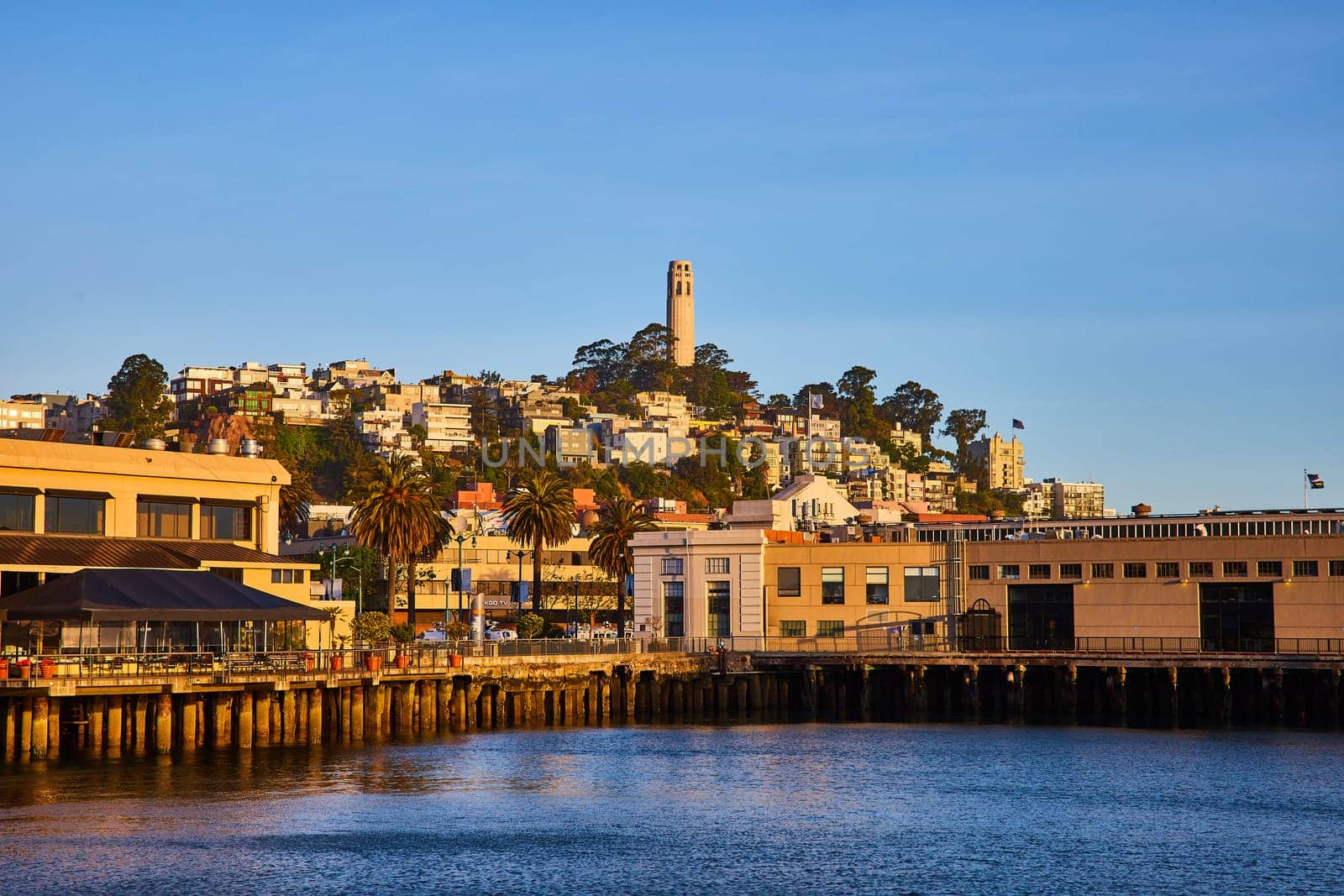 Image of Shoreline with docks on San Francisco Bay looking up at Telegraph Hill and Coit Tower at sunset