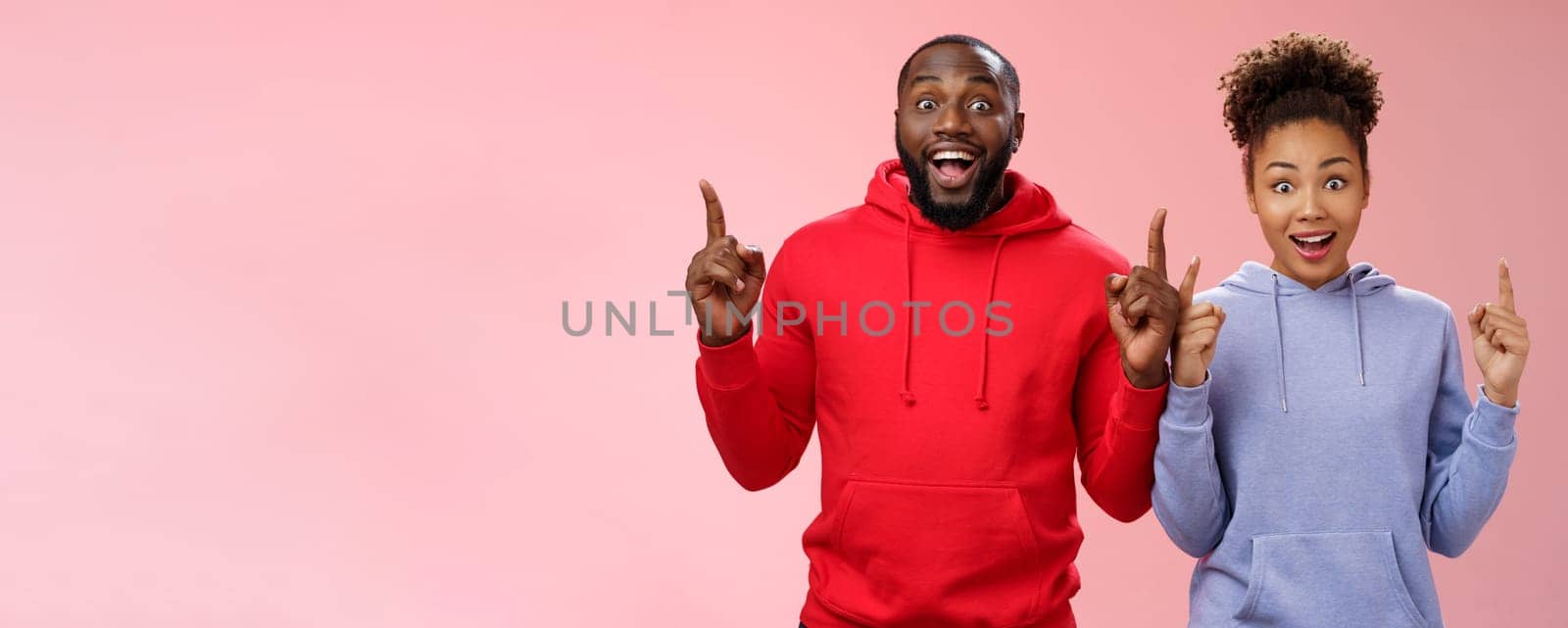 Lifestyle. Amused charismatic two best friends african american brother sister pointing raised index fingers up widen eyes imressed amused feel happy go study abroad together winning trip standing surprised.