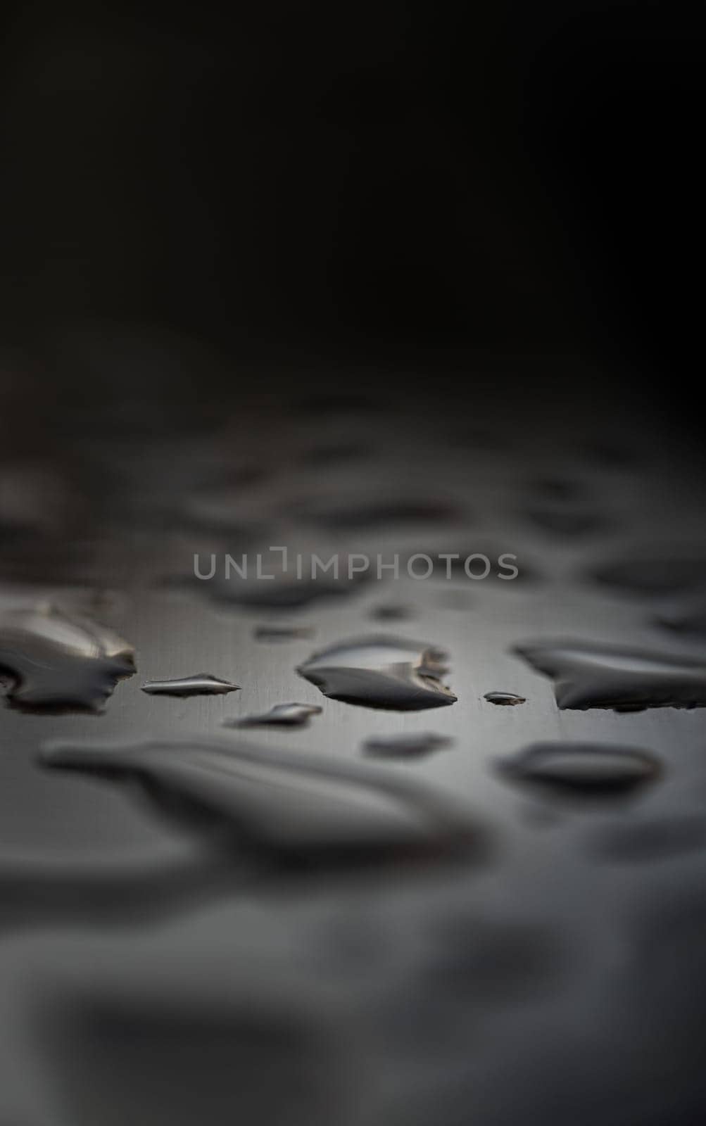 Detail of Water droplets caused by rain perched on the metallic surface. Rain water drops on a stainless steel handle, Natural Pattern of dew drops or raindrops on silver metal background for wallpaper poster and banner design, Selective focus.