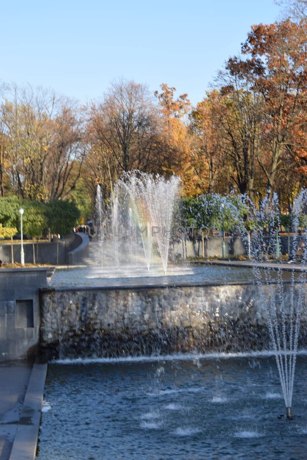 Water stream splashing on ground. The fountain in autumn garden