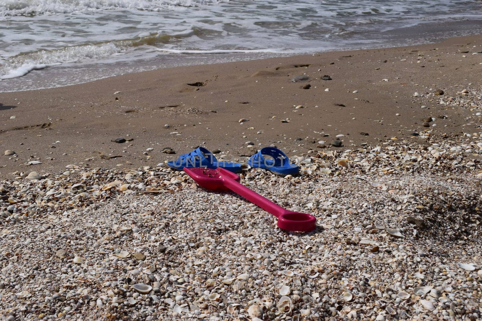 Beach background with flip flop and plastic spade. holiday and vacations concept.