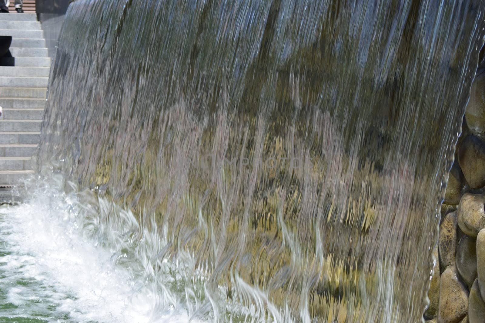 artificial waterfall, city fountain, close-up pouring water.