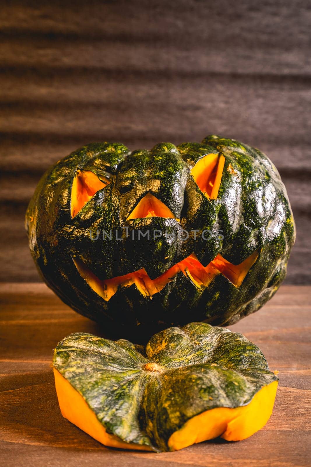 Two small pumpkins carved for Halloween. On a dark background.