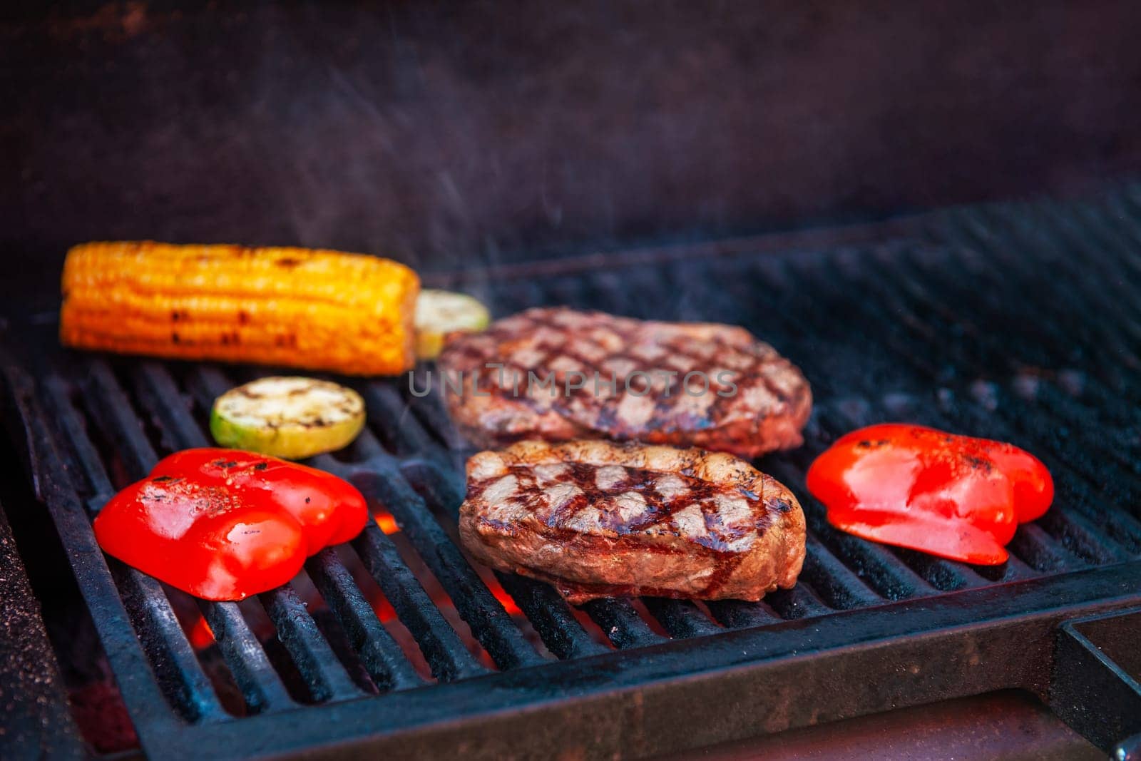 Pork meat steaks on the grill with flames
