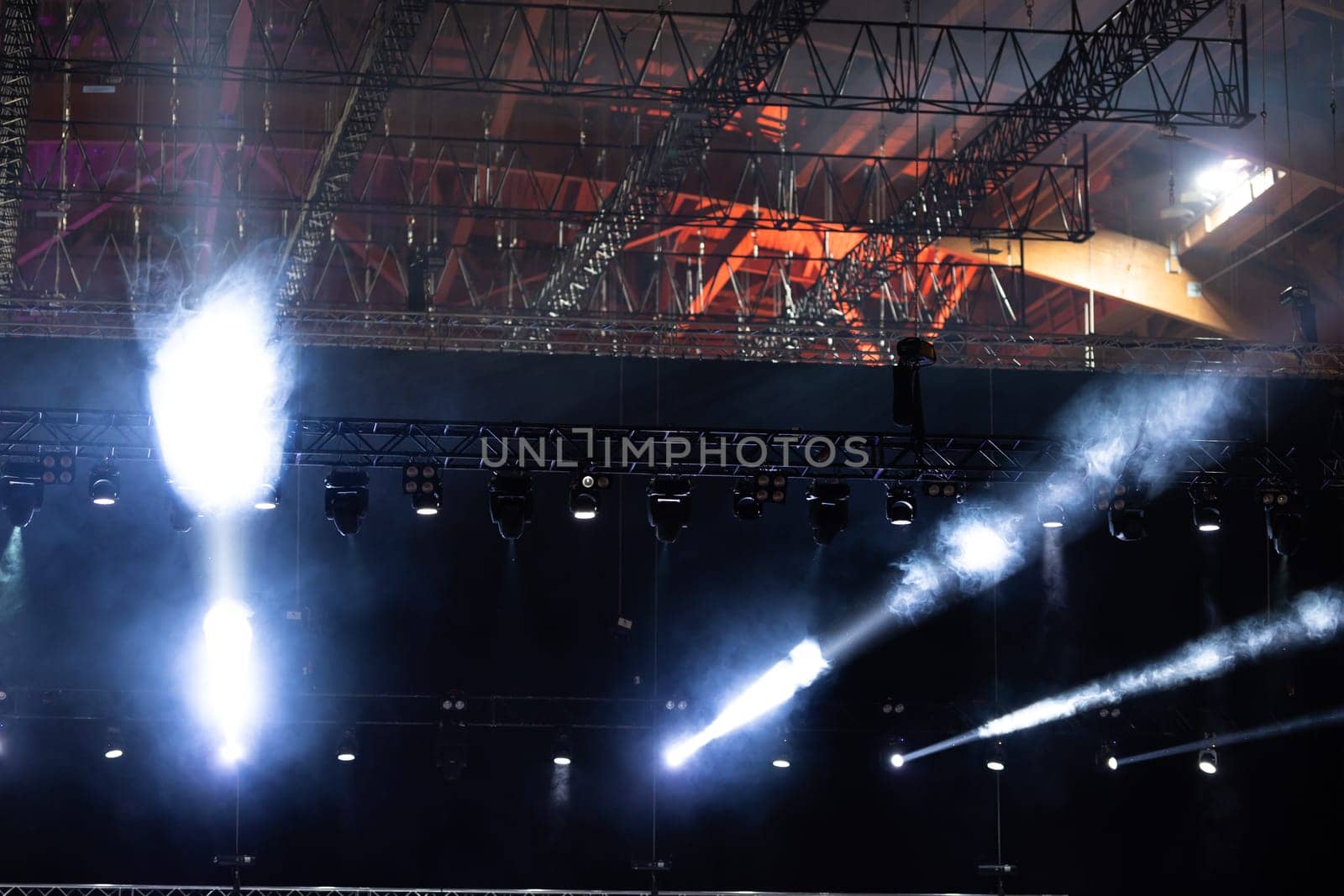 The ceiling of the concert hall and illumination spotlights illuminate the stage. Mid shot