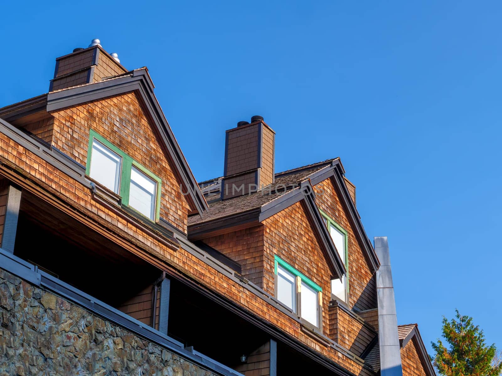 Residential condo with attic bedrooms on blue sky background.