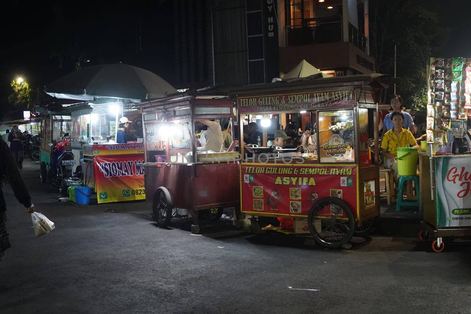 August 14, 2024. Jakarta, Indonesia. A bustling night scene in a corner of the city, filled with street vendors and shoppers.