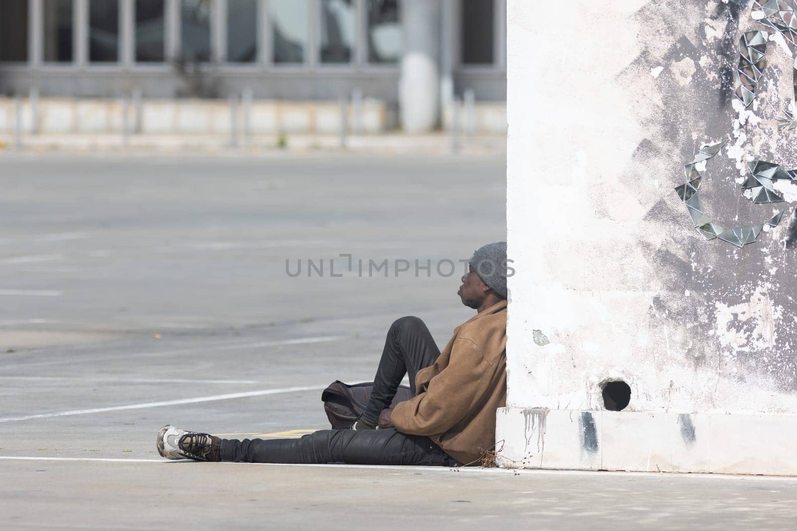 March 12, 2023 Lisbon, Portugal: black homeless person sitting on the street. Mid shot