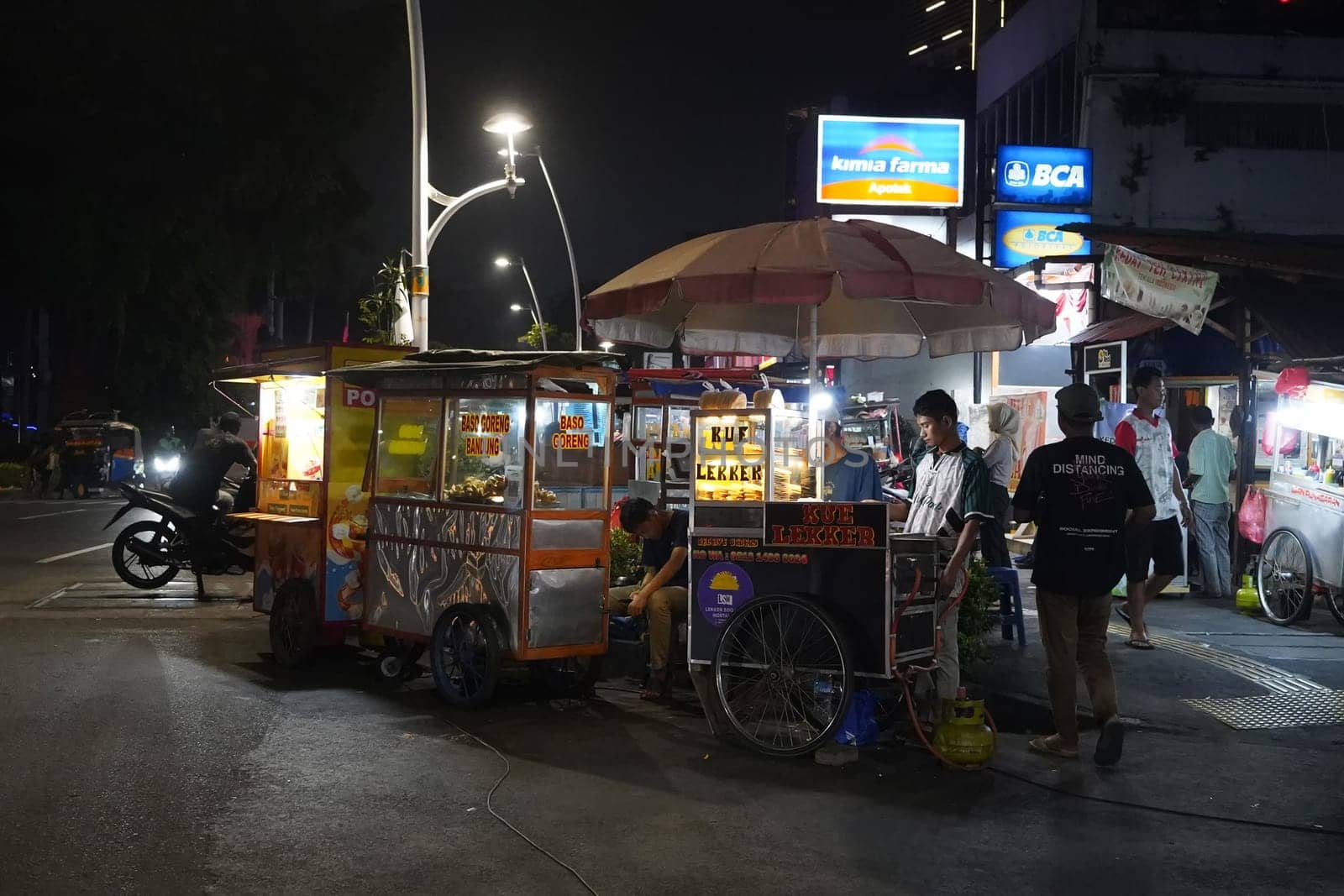 August 14, 2024. Jakarta, Indonesia. A bustling night scene in a corner of the city, filled with street vendors and shoppers.