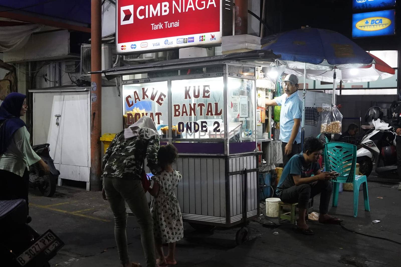 August 14, 2024. Jakarta, Indonesia. A bustling night scene in a corner of the city, filled with street vendors and shoppers.