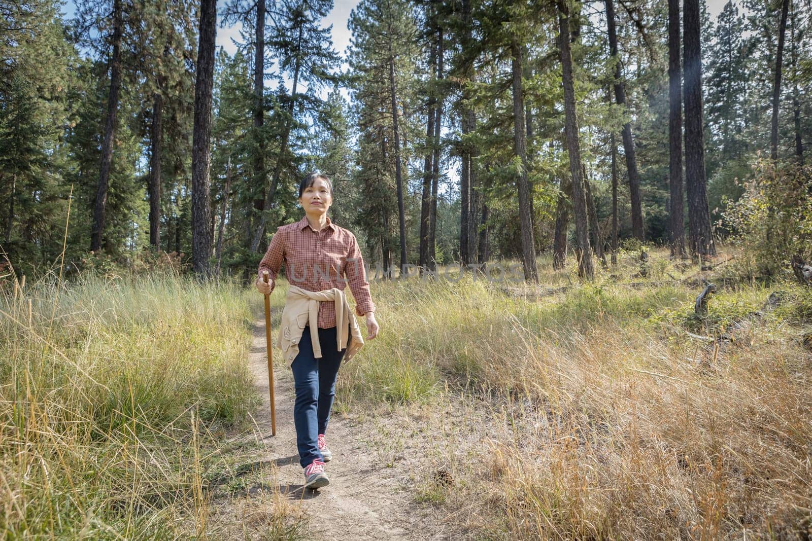 An asian woman enjoys a nice day hike at a trail near Coeur d'Alene, Idaho.