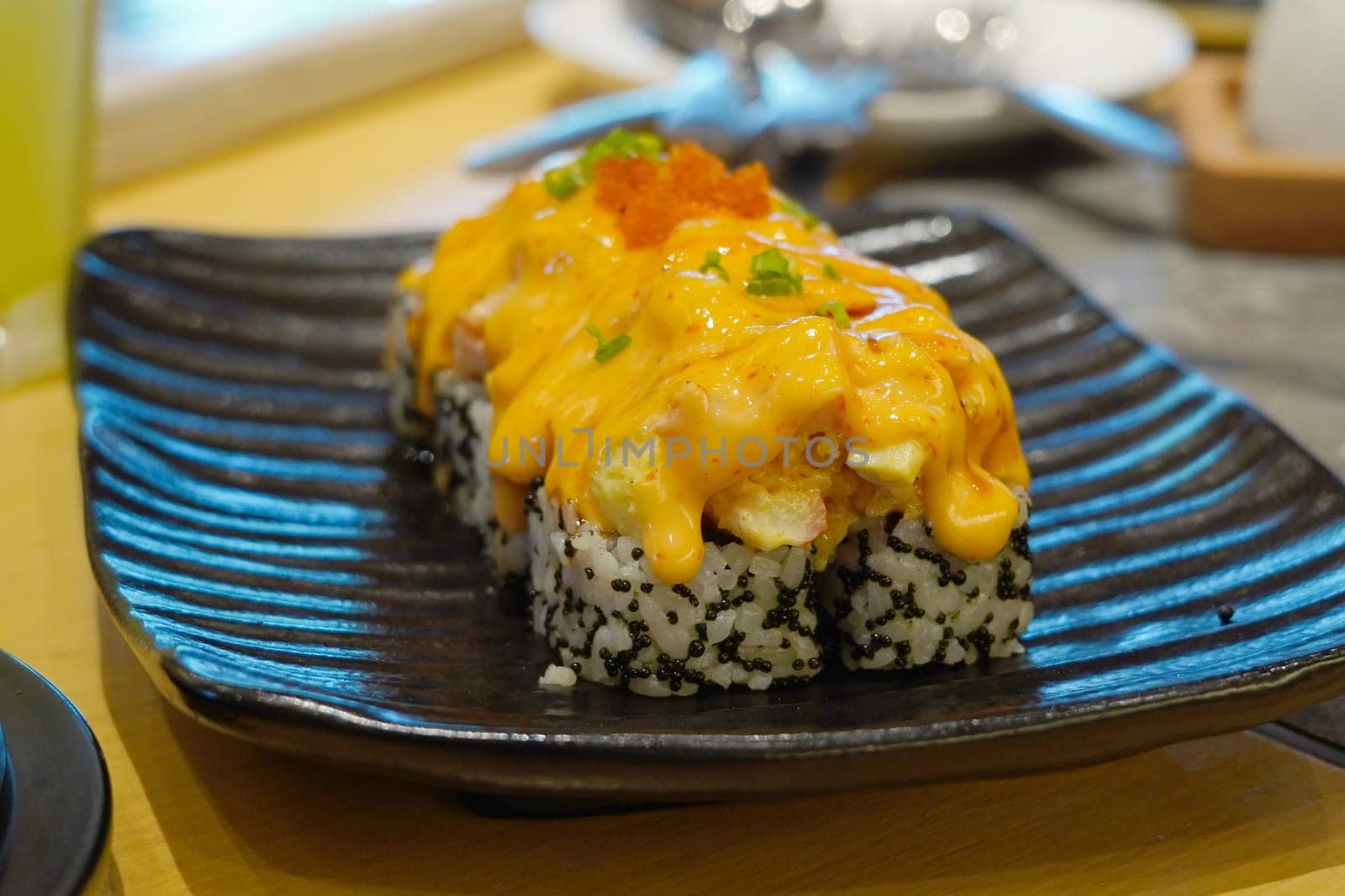 A mouthwatering sushi roll topped with a creamy, spicy sauce and a sprinkle of fish roe.