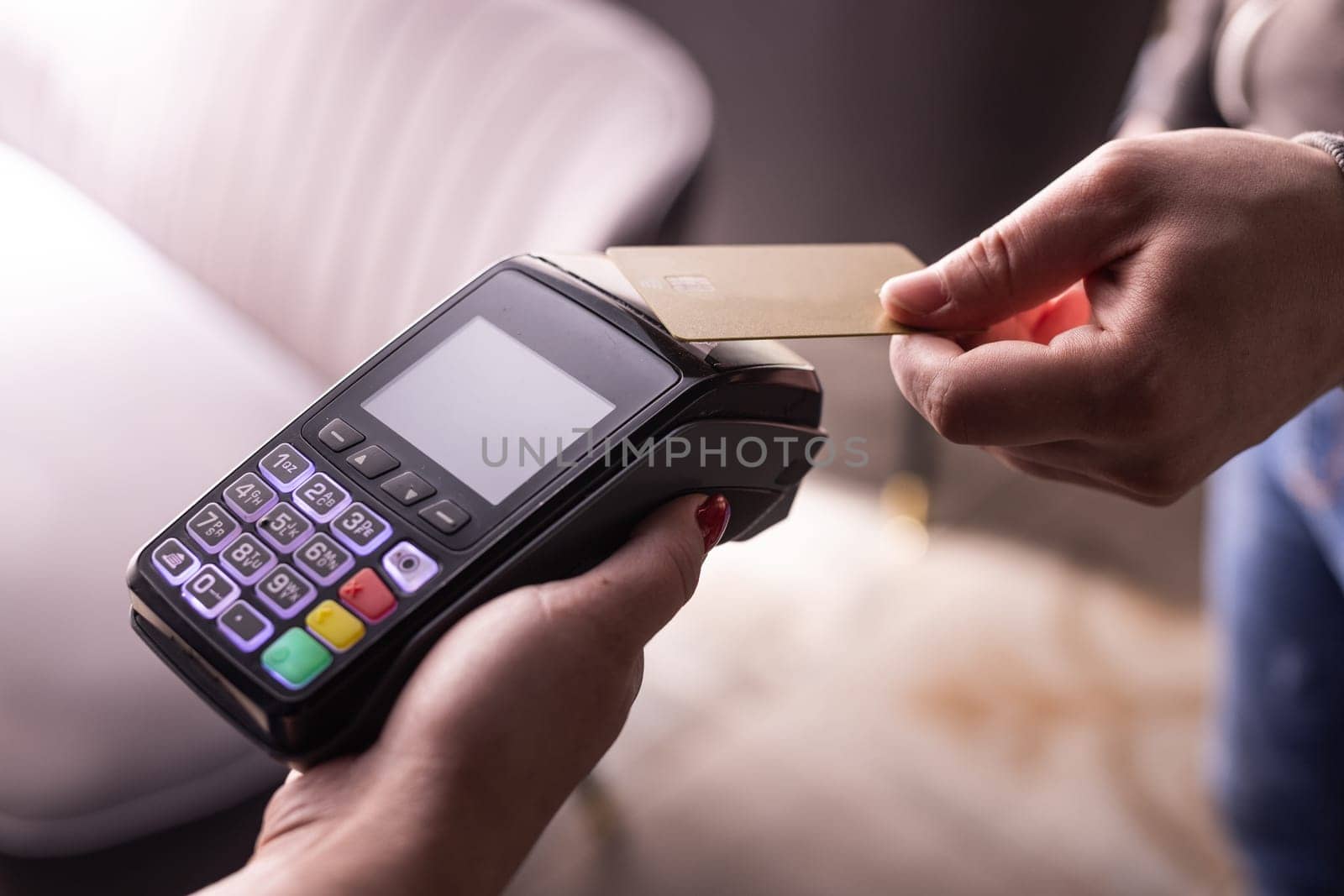 NFC credit card payment. Woman paying with contactless credit card with NFC technology. Wireless money transaction. Card machine in male hand on sunlight background