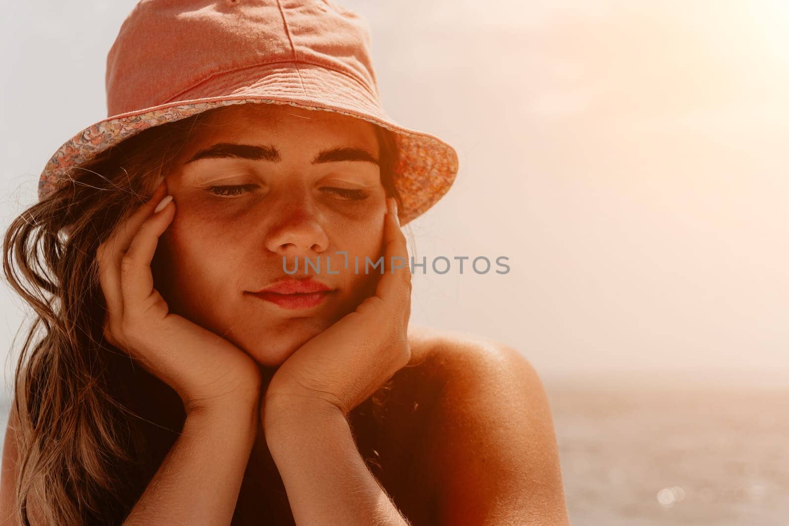 Happy smiling young woman sunbathing or tanning on a seaside beach during summer vacation. Slow motion of happy tourist in red swimsuit enjoying sun tan lying on beach chair lounge at luxury resort.