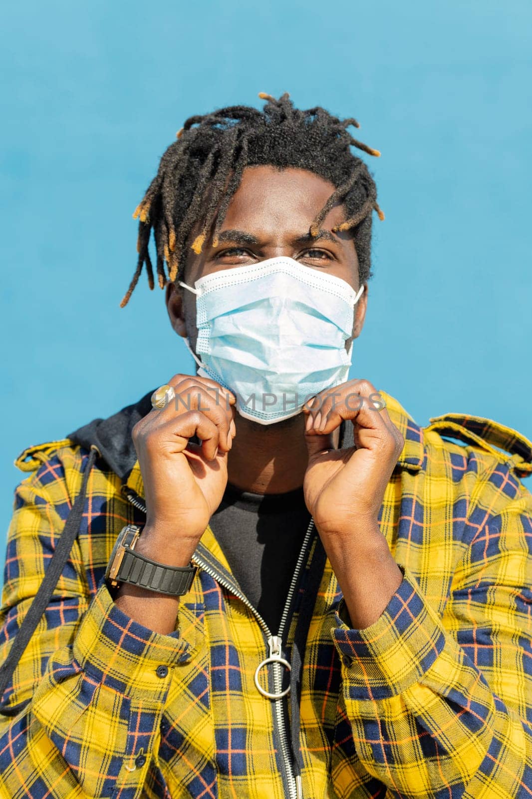 vertical photo of an attractive young black man wearing a protective mask, lifestyle concept and virus protection