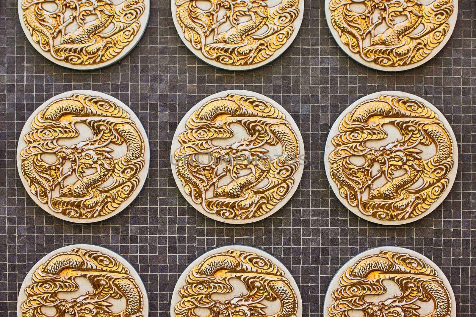 Image of Close up of three golden dragon coins on black tile background