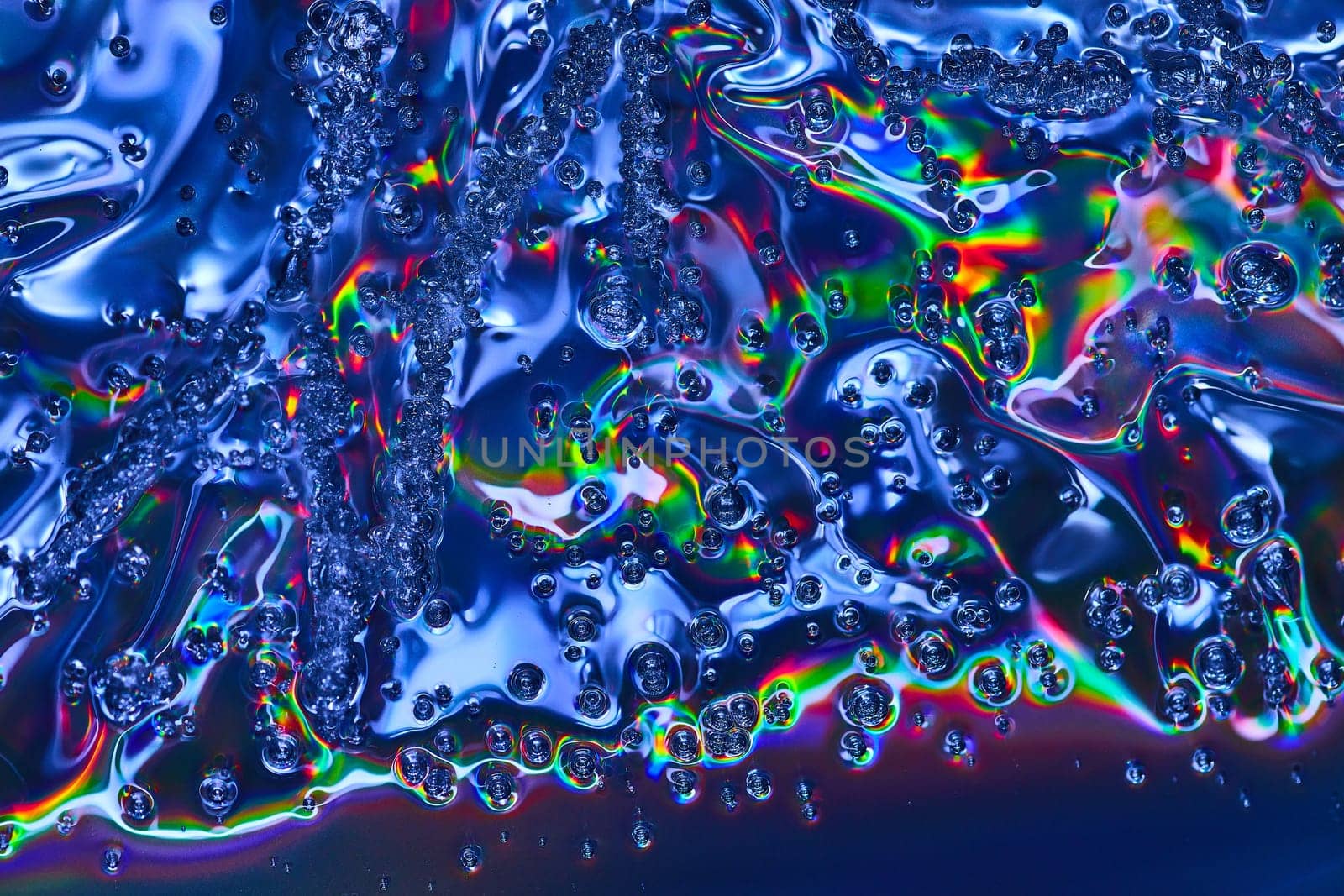 Image of Vibrant abstract art with rainbow colors in bubbles flowing across wavy oily surface background