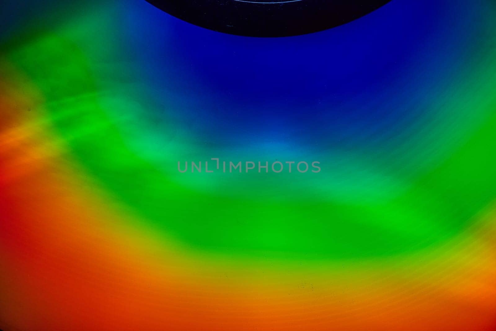 Image of Partial black circle at top with abstract waves of blue and green and red in arc background asset
