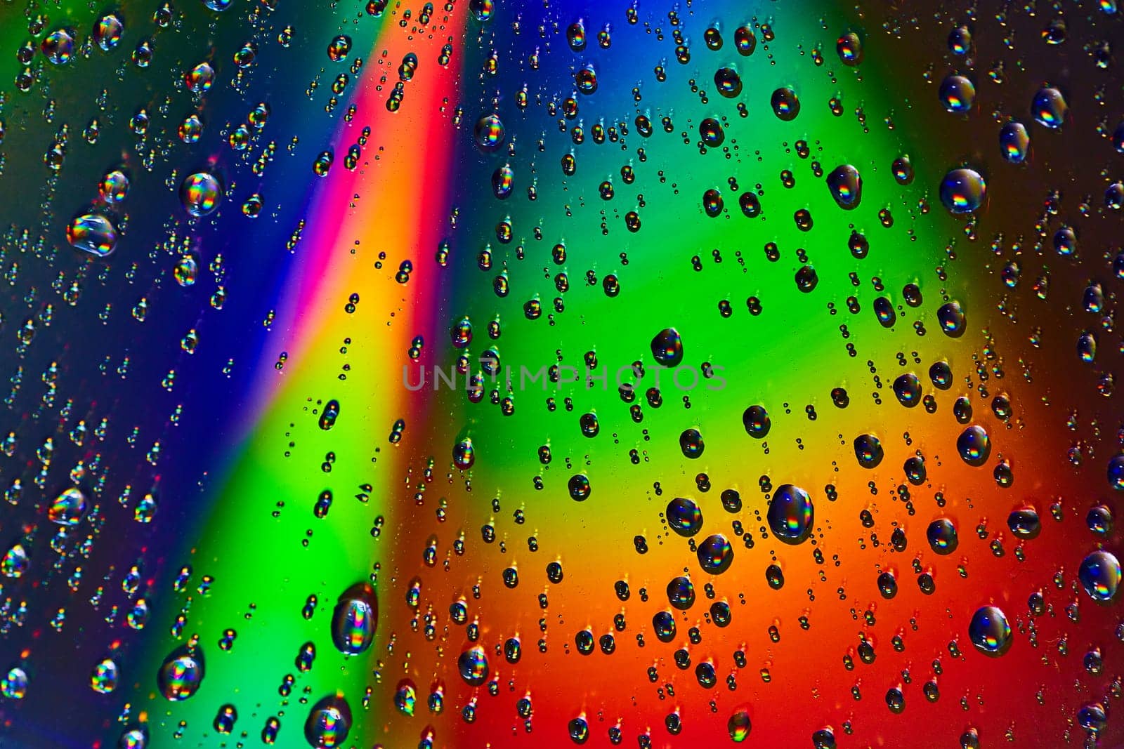 Image of Beam of light across abstract rainbow colored background with rain drops background asset