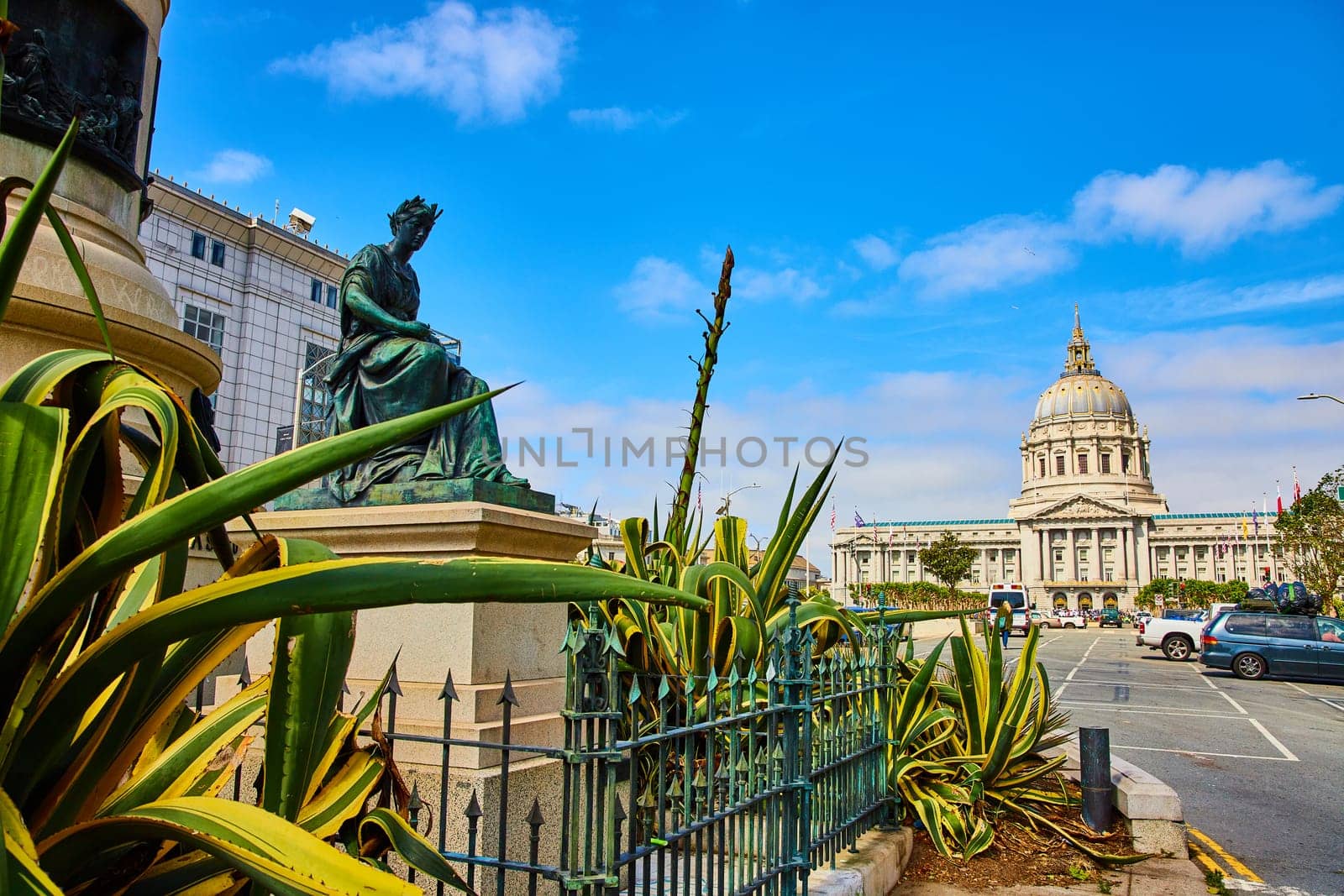 Image of Plants beside Pioneer Monument with distant city hall on blue sky day with soft purple clouds