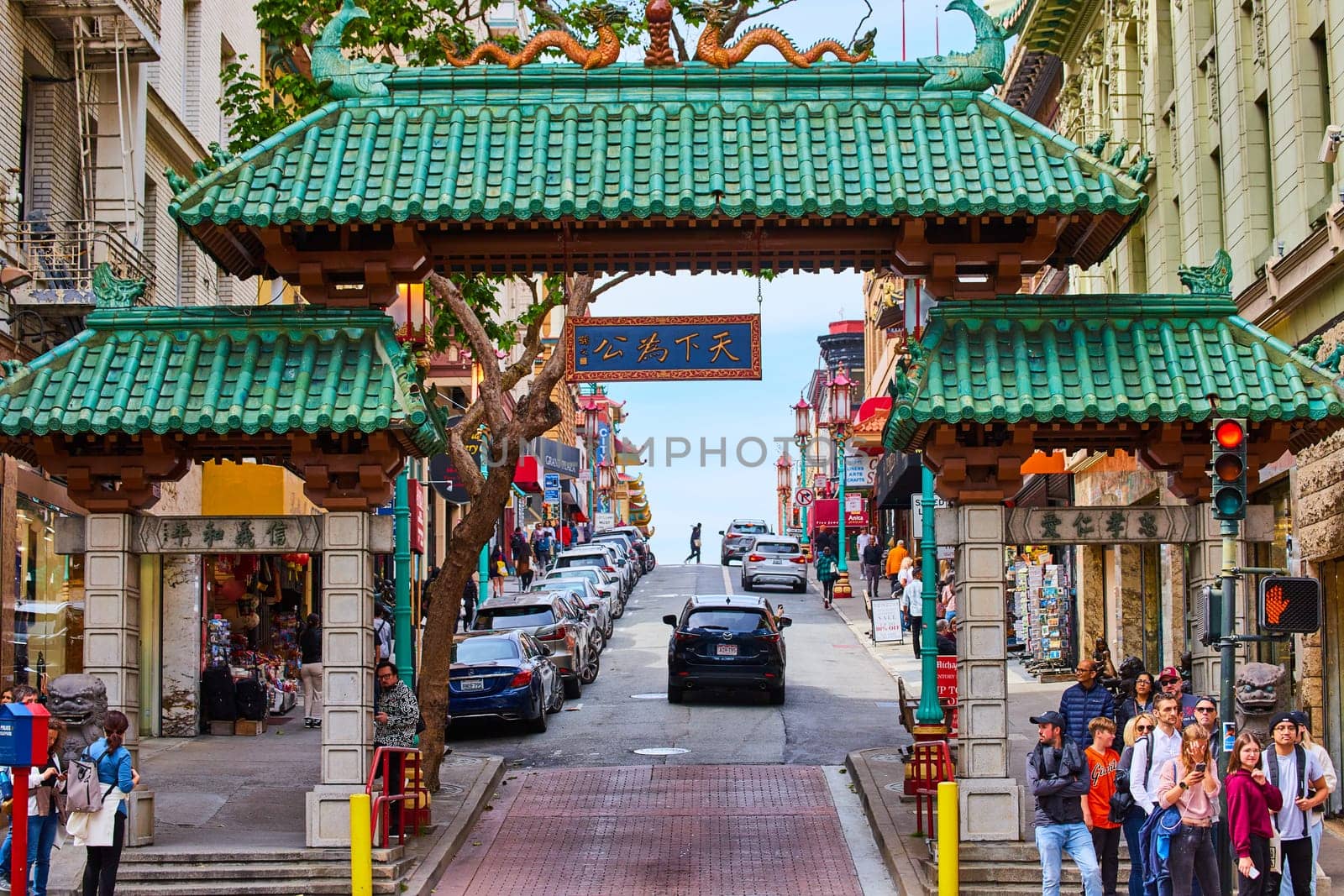 Image of Cars driving up hill through iconic green Chinatown entrance in San Francisco
