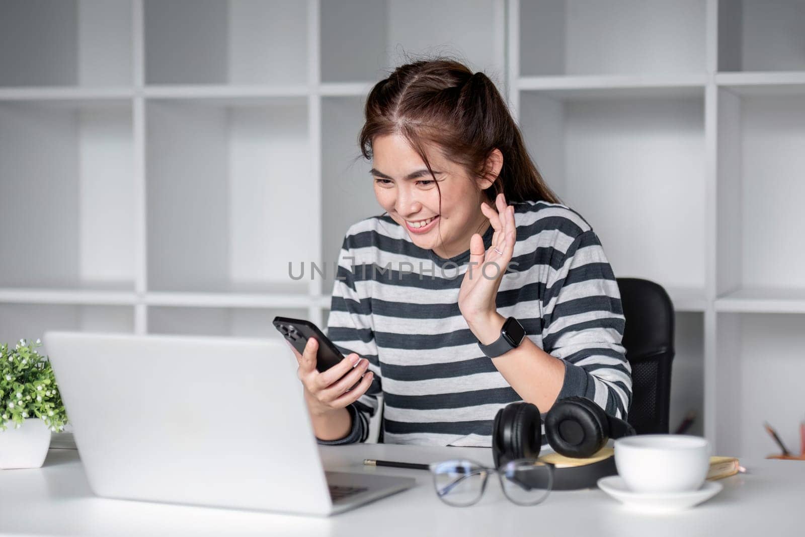 Young female student studying online through decoupage happily with laptop computer in living room..