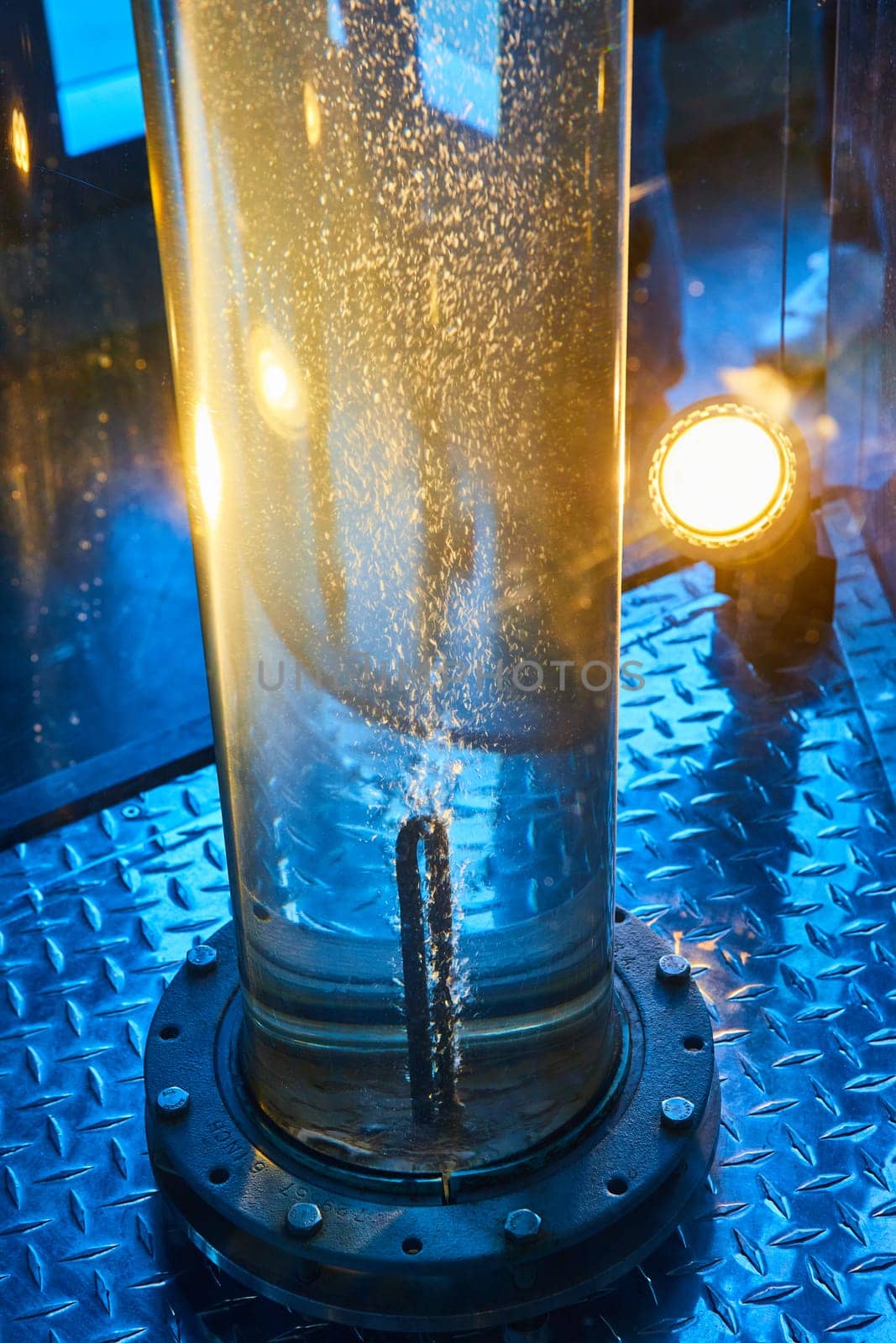 Image of Water in clear tube on metal plate with light illuminating bubbles as they rise