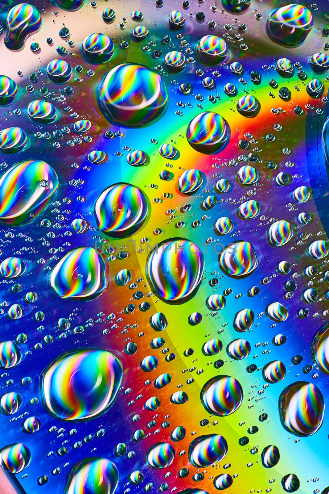 Image of Silvery swirling water drops in cosmic rainbow Saturn ring in psychedelic background asset