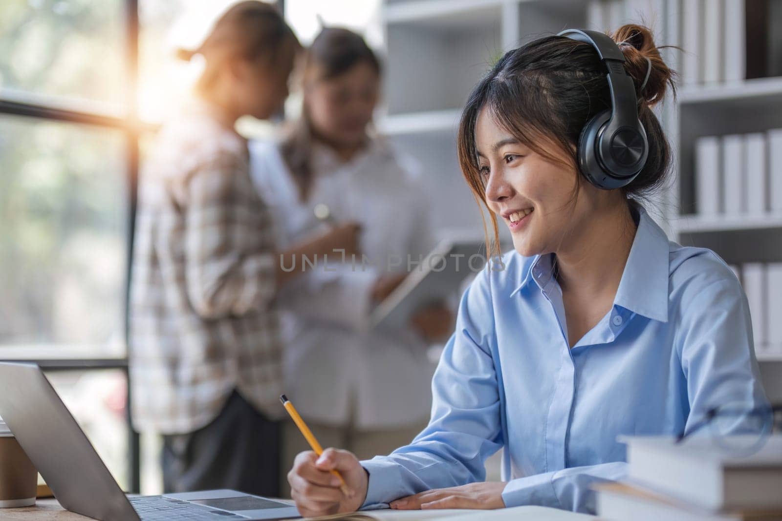 College students using laptop while sitting at table. Group study for school assignment