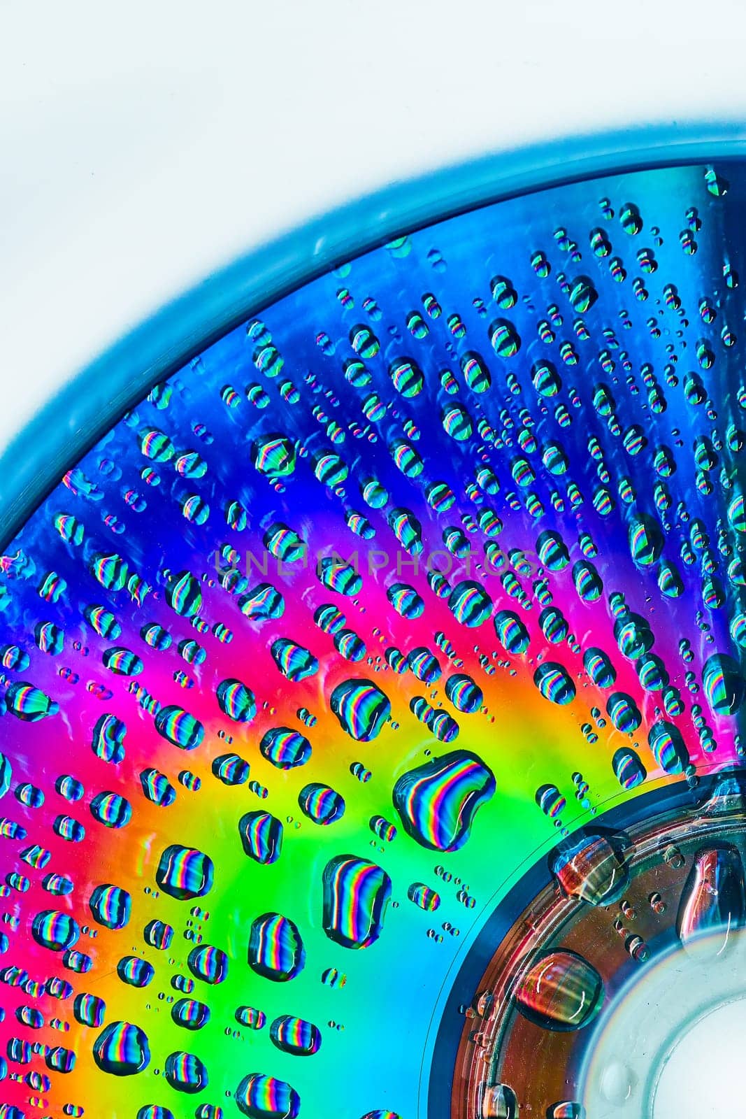Image of Brilliant burst of rainbow colors on metallic surface with water drops abstract background asset