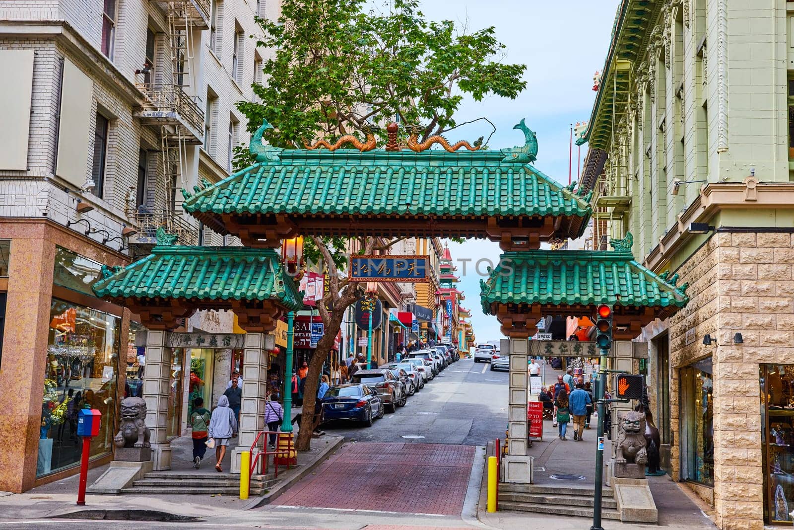 Image of People walking into Chinatown in San Francisco through main green roofed entrance