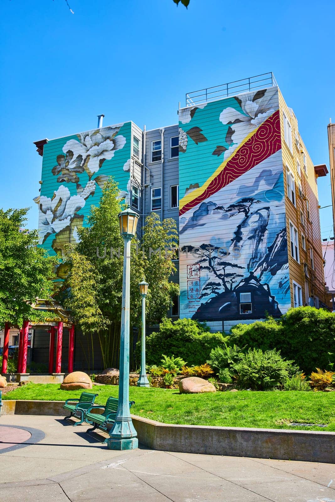 Image of Peaceful and zen art mural on buildings overlooking sunny park with green benches